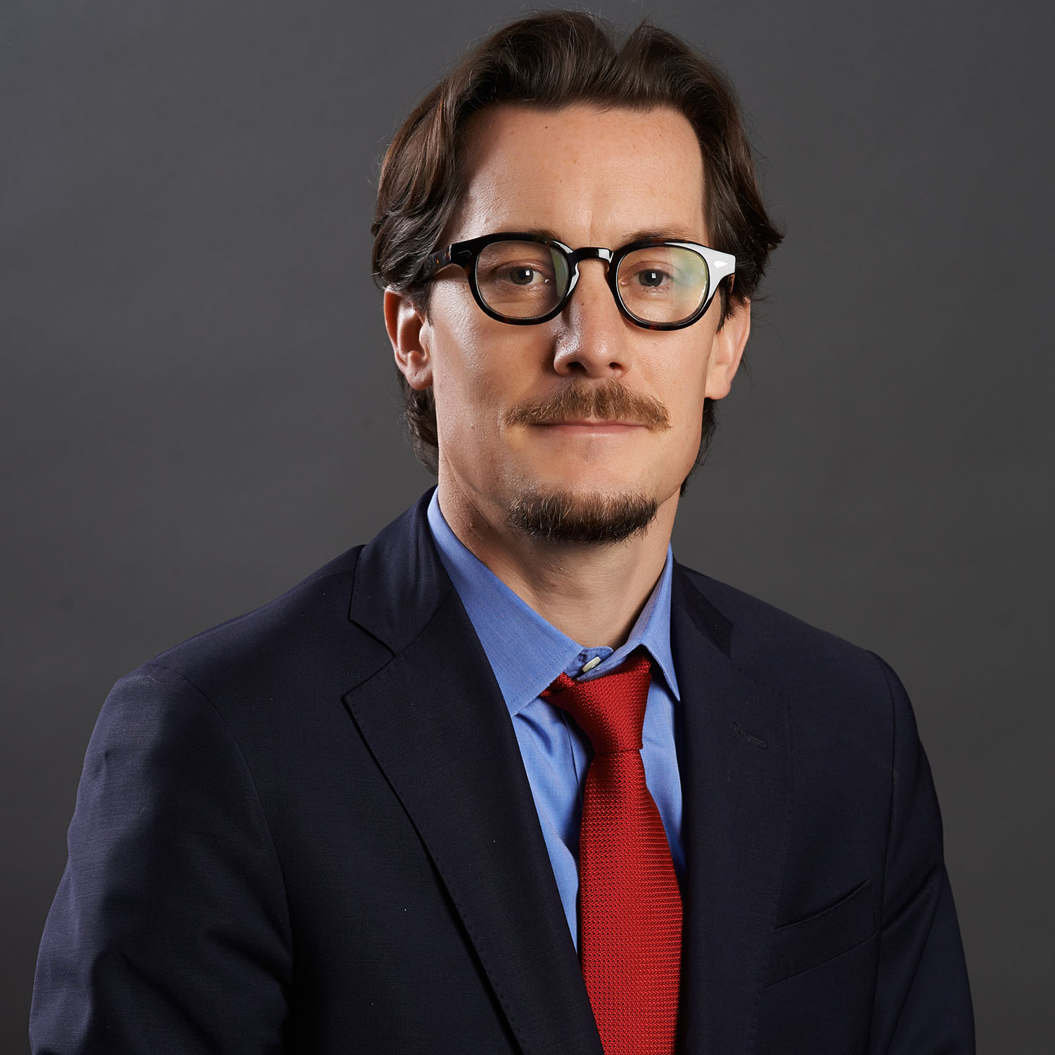 Professional headshot of a man against a gray gradient background — Headshots by Guffy, San Diego