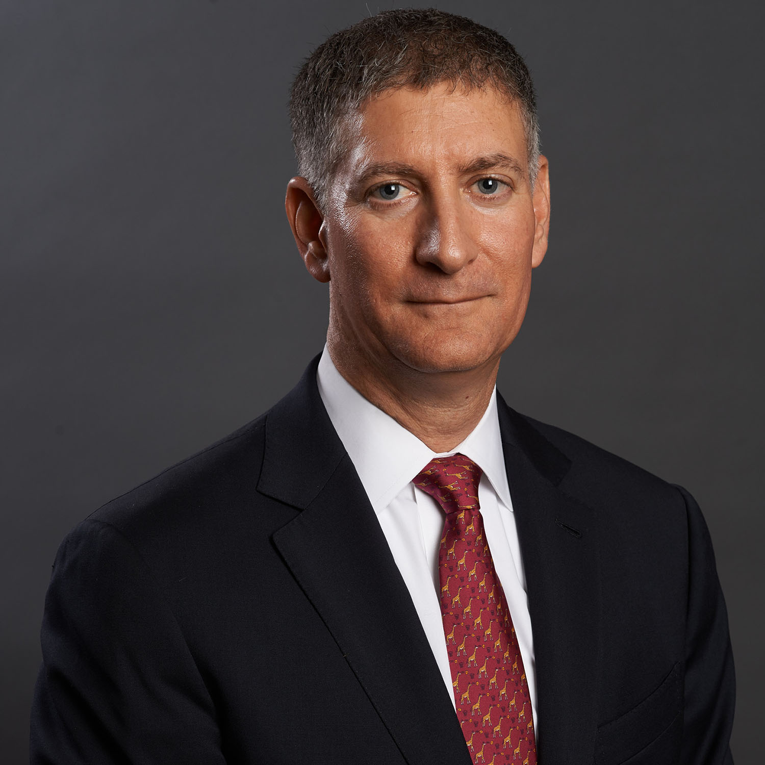 Executive headshot of a man against a gray gradient background — Headshots by Guffy, San Diego