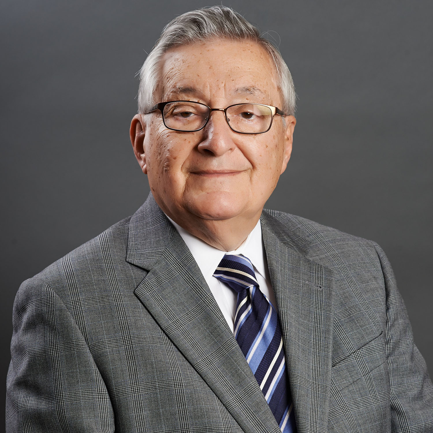 Executive headshot of a man against a gray gradient background — Headshots by Guffy, San Diego